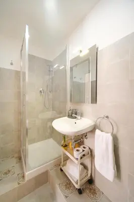 a white bathroom with a sink and a shower at Vatican Domus by BuddyRent in Rome