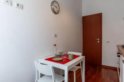 a white table with chairs and a clock on the wall at GuestHost - Close to St Peter in Rome