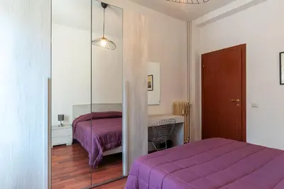 a bedroom with a purple bed and a mirror at GuestHost - Close to St Peter in Rome