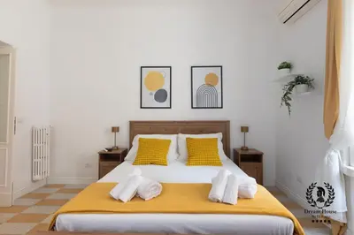 a bedroom with a large white bed with yellow pillows at Dream House Re di Roma - 50mt to Metro Station, central position, 4pax, 2bdr in Rome