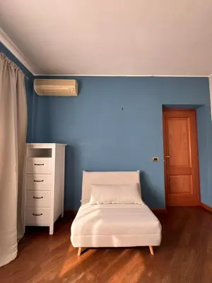 a bedroom with a bed and a dresser and a blue wall at Vatican District, Roma, alloggio centrale in Rome