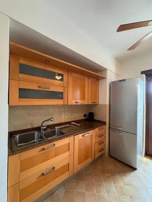 a kitchen with wooden cabinets and a stainless steel refrigerator at Vatican District, Roma, alloggio centrale in Rome