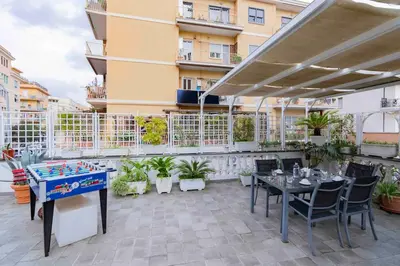 a patio with a ping pong table and chairs at Hermès Apartment Rome in Rome
