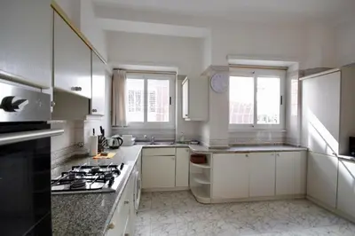 a kitchen with white cabinets and a stove top oven at HC - Baldo degli Ubaldi Elegant Apartment in Rome