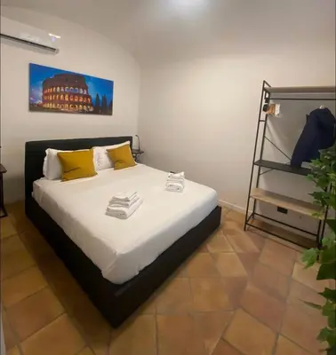 a bedroom with a bed with yellow pillows and a shelf at Cozy Colosseo in Rome