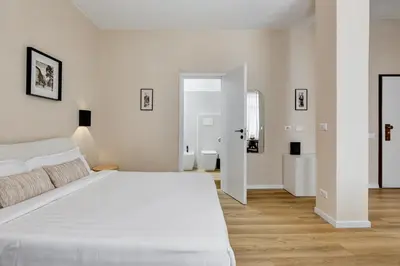 a white bedroom with a large bed and a bathroom at Urbana 24 in Rome