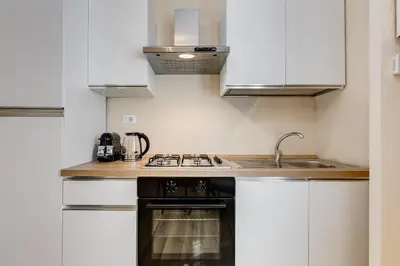 a kitchen with white cabinets and a sink at Urbana 24 in Rome