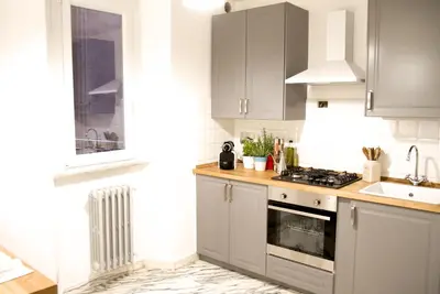 a kitchen with gray cabinets and a stove top oven at Abbituè Apartment in Rome