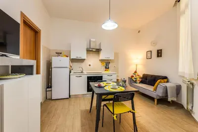 a kitchen and a living room with a table and chairs at Roger apt in Rome
