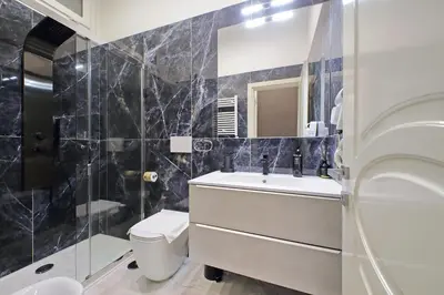 a bathroom with a sink and a toilet and a mirror at Duplex Elegante a 2 Min dal Vaticano e dalla Metro in Rome