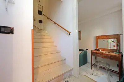a hallway with a staircase with a desk and a mirror at Duplex Elegante a 2 Min dal Vaticano e dalla Metro in Rome