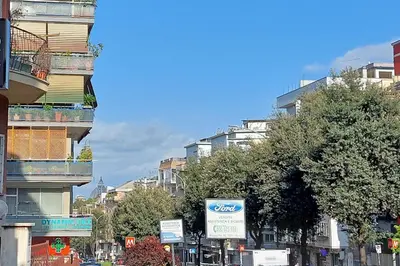 a city street with tall buildings and a sign at Duplex Elegante a 2 Min dal Vaticano e dalla Metro in Rome