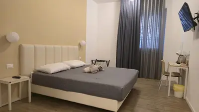 a bedroom with a bed and a table and a desk at Domus Regis Rooms in Rome