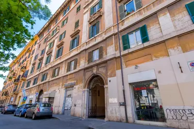 a large building with cars parked in front of it at Elegantis Labicana Apartment - Few steps from the Colosseum in Rome