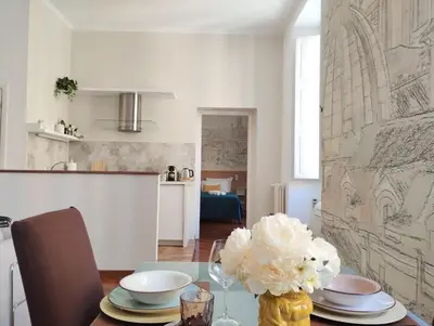 a dining room table with a vase of flowers on it at Dimora Roma Eterna, vacation & business in Rome