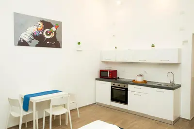 a kitchen with white cabinets and a table and chairs at Manara10 Apart Blu1 in Rome