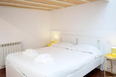 a bedroom with a white bed with towels on it at Manara10 Apart giallo2 in Rome