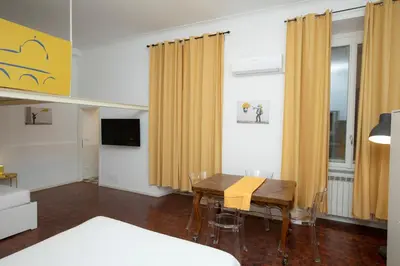a living room with a dining room table and yellow curtains at Manara10 Apart giallo2 in Rome