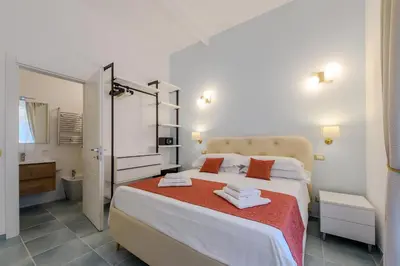 a bedroom with a large bed and a bathroom at Magnoliahome Suites at the Vatican in Rome