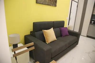 a black couch with pillows on it in a living room at Emma and Livia's Vatican Suite 2 in Rome
