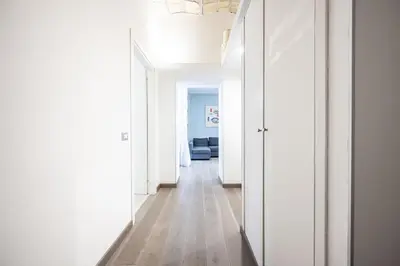 a hallway in a apartment with white walls and wood floors at Casa Sistina in Rome