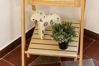 a wooden horse statue next to a potted plant at Vatican Apartment 2 minuti da città del vaticano in Rome