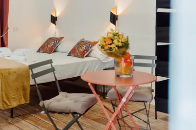 a table with a vase of flowers on it with a bed at Monti Urban Studio by Valentina's Dream in Rome