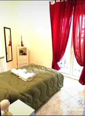 a bedroom with a bed with red curtains at Asia Guest House in Rome