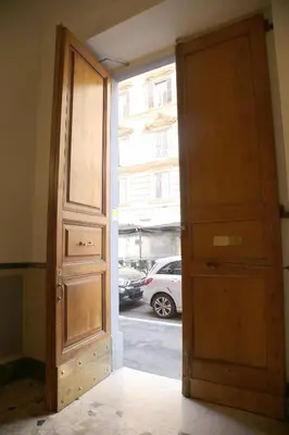 an open wooden door with a window and a car at Emma and Livia's Vatican Suite 1 in Rome