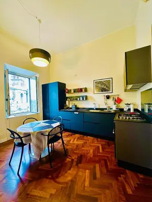 a kitchen with blue cabinets and a table with chairs at Santa Maria Maggiore Suites Apartments in Rome