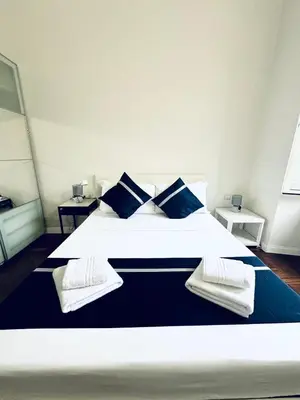 a bedroom with a large white bed with blue pillows at Santa Maria Maggiore Suites Apartments in Rome