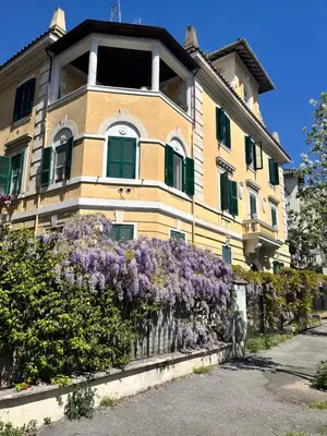 a yellow building with purple flowers in front of it at Gianicolo Hill Apartment in Rome
