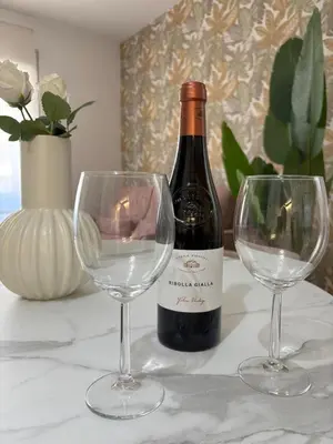 a bottle of wine and two wine glasses on a table at Aulo Plauzio Apartment in Rome