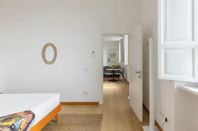 a bedroom with a bed and a hallway with a table at iFlat Bright & Modern Living with Panoramic View in Rome