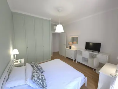 a white bedroom with a bed and a tv at San Paolo Charme Apartment in Rome