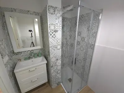 a bathroom with a shower and a sink and a mirror at San Paolo Charme Apartment in Rome