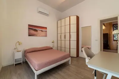 a bedroom with a bed and a desk and a table at GuestHost Cozy Flat X4 - 450m to Vatican City! in Rome
