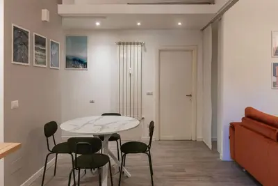 a living room with a table and chairs and a couch at GuestHost Cozy Flat X4 - 450m to Vatican City! in Rome