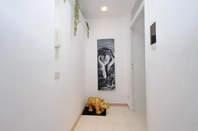 a hallway with a white wall with a picture and a statue at 4BNB - Annibaliano Metro Apartment in Rome