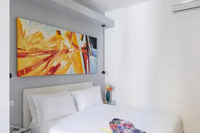 a bedroom with a white bed and a painting on the wall at iFlat Stylish & Cozy Vatican Peaceful Gem in Rome