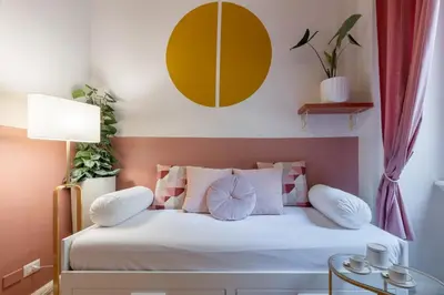 a bedroom with a bed with white and pink pillows at The 38 Home Exclusive - Homkeey Apartments in Rome