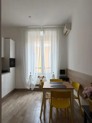 a dining room with a table and chairs and a window at Dimora Vaticano Rome Apartments in Rome