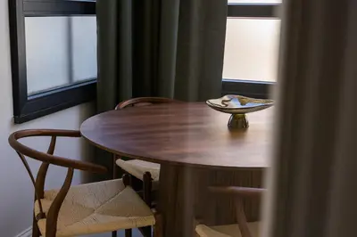 a wooden table and chairs in a room with windows at La Terrazza di Ermini in Rome