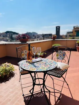 a table with two glasses of wine on a balcony at Enzo House in Rome