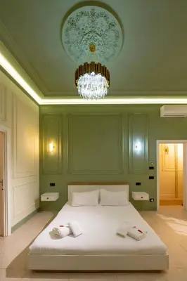a bedroom with a large white bed with a chandelier at Mia House Prestige in Rome