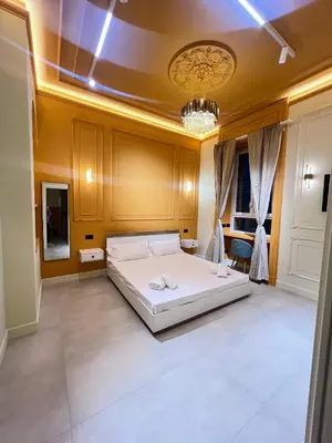 a bedroom with a large white bed and a chandelier at Mia House Prestige in Rome