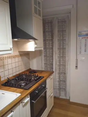 a kitchen with a stove top oven next to a window at Alloggio turistico Artù in Rome