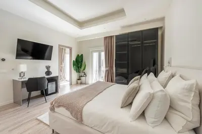 a white bedroom with a large bed with white pillows at Domus 28 in Rome