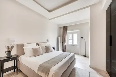 a white bedroom with a large bed and a window at Domus 28 in Rome
