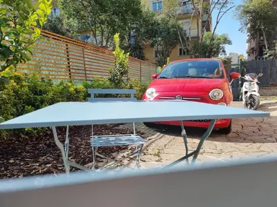 a red car parked in a parking lot with a table at Pigneto Giardino e Posto Auto Privati in Rome